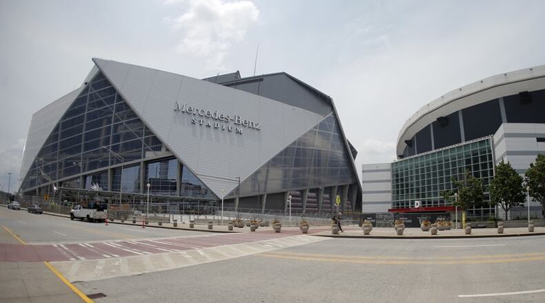 Mercedes-Benz Stadium, left, the new home of the Atlanta Falcons and Atlanta United, is shown next to the Georgia Dome. (Credit: John Bazemore/Associated Press)