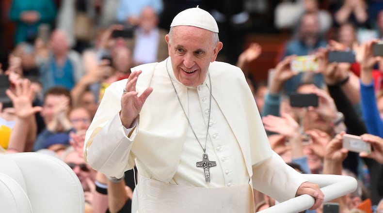 Pope Francis waves to the waiting crowds on College Green, Dublin, as he travels in the Popemobile during his visit to Ireland, Saturday, Aug. 25, 2018.