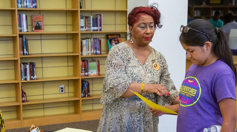 Media Daniels (left) helps Sabina Arnesen get information about Grambling State University during a college and career expo hosted at Fredrick Douglass High School, in Atlanta, on Wednesday, July 24, 2019, as part of a program offering summertime support to recent Atlanta high school graduates. (Photo by Phil Skinner)