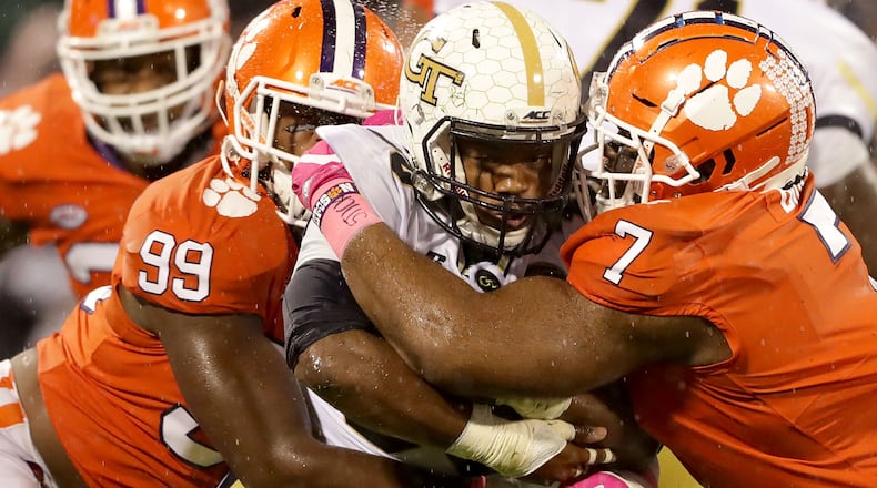 CLEMSON, SC - OCTOBER 28:  Teammates Clelin Ferrell #99 and Austin Bryant #7 of the Clemson Tigers try to stop KirVonte Benson #30 of the Georgia Tech Yellow Jackets during their game at Memorial Stadium on October 28, 2017 in Clemson, South Carolina.  (Photo by Streeter Lecka/Getty Images)