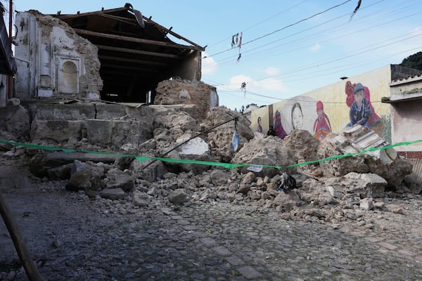 A man walks past the damaged Catholic Church El Calvario in Santa Maria de Jesus, Guatemala, Wednesday, July 9, 2025, following dozens of earthquakes and aftershocks that were recorded in a matter of hours. (AP Photo/Moises Castillo)