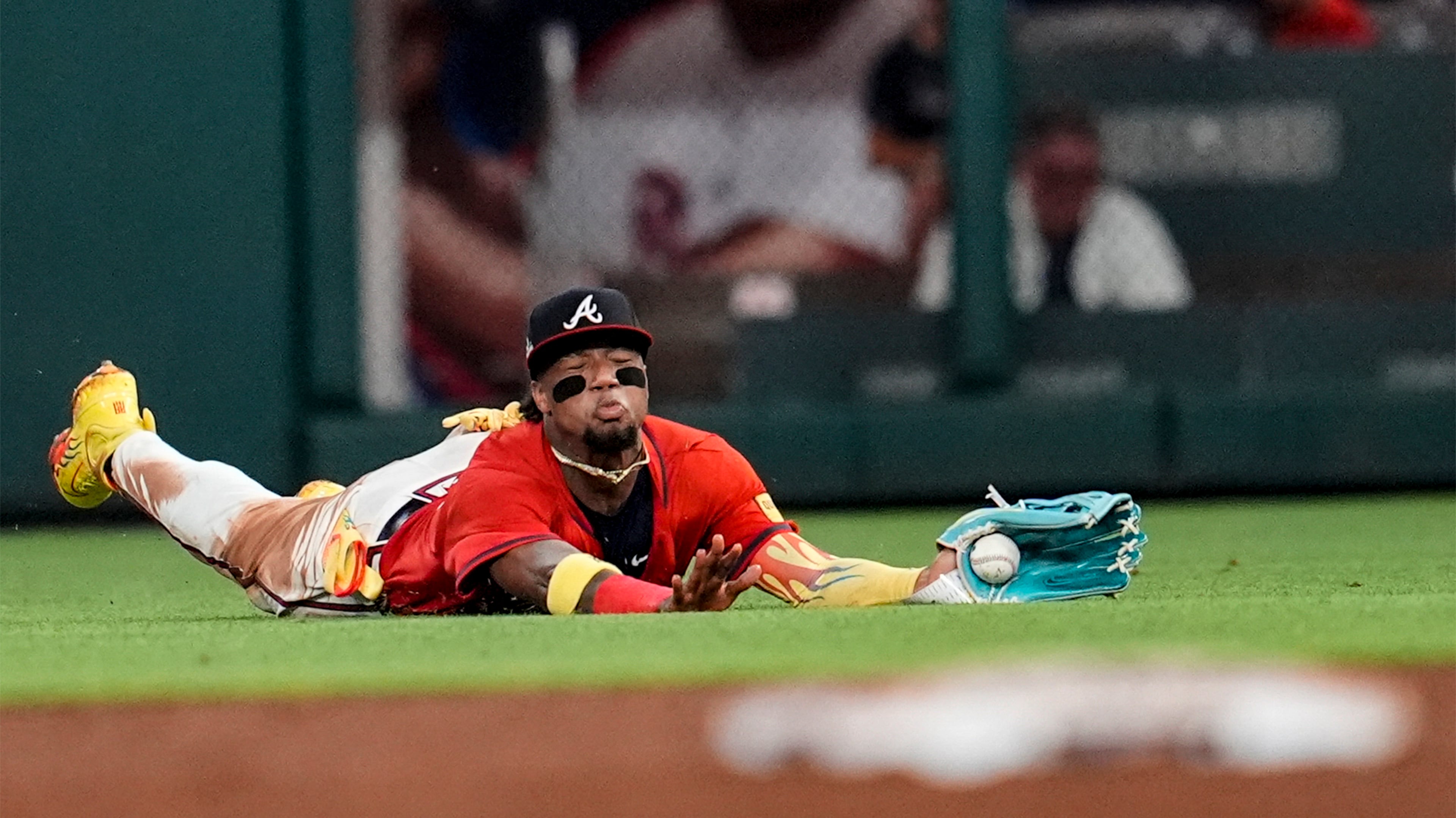 Braves outfielder Ronald Acuña Jr. misses the catch off the bat of the Rockies' Kyle Farmer in the ninth inning of Friday's game at Truist Park in Atlanta. (Mike Stewart/AP)