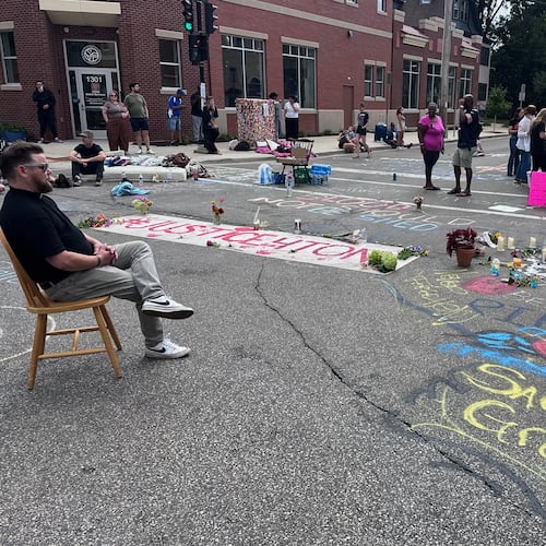Mourners gather around a memorial at the site where a man was shot and killed on Wednesday by Madison police, Thursday, July 23, 2026, in Madison, Wis. (AP Photo/Scott Bauer)