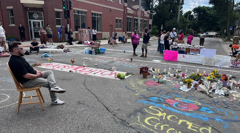 Mourners gather around a memorial at the site where a man was shot and killed on Wednesday by Madison police, Thursday, July 23, 2026, in Madison, Wis. (AP Photo/Scott Bauer)