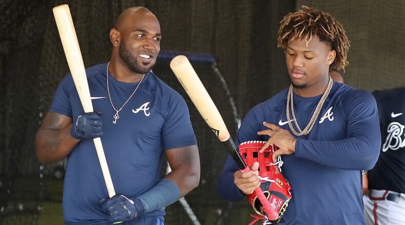 Braves outfielders Marcell Ozuna (left) and Ronald Acuna (right) talk in the batting cages at spring training last month.