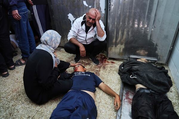 The parents of Palestinian youth Ahmad Omar, 15, mourn over his body, at the morgue of Al-Aqsa Hospital in Deir al-Balah, after he was killed in an Israeli army airstrike on the Gaza Strip, Sunday, April 27, 2025. (AP Photo/Abdel Kareem Hana)