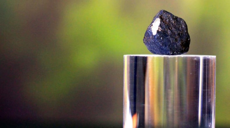 A piece of stony-iron meteorite sits on a display during a press conference, Friday, Jan. 19, 2018, at the Longway Planetarium in Flint, Mich. Longway Planetarium astronomers have located three meteorites, after a meteor broke apart about 20 miles over Earth Tuesday. Most of the meteoriteâs fragments landed in Hamburg Township, Mich. The meteor will be sent to NASA for analysis. (Bronte Wittpenn/The Flint Journal-MLive.com via AP)