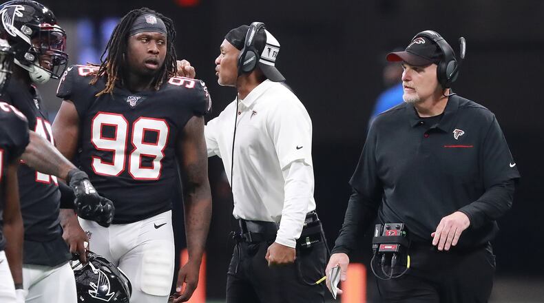 Falcons defensive end Takk McKinley looks to head coach Dan Quinn for direction during a time out Sunday, Sept. 29, 2019, against the Tennessee Titans at Mercedes-Benz Stadium in Atlanta.