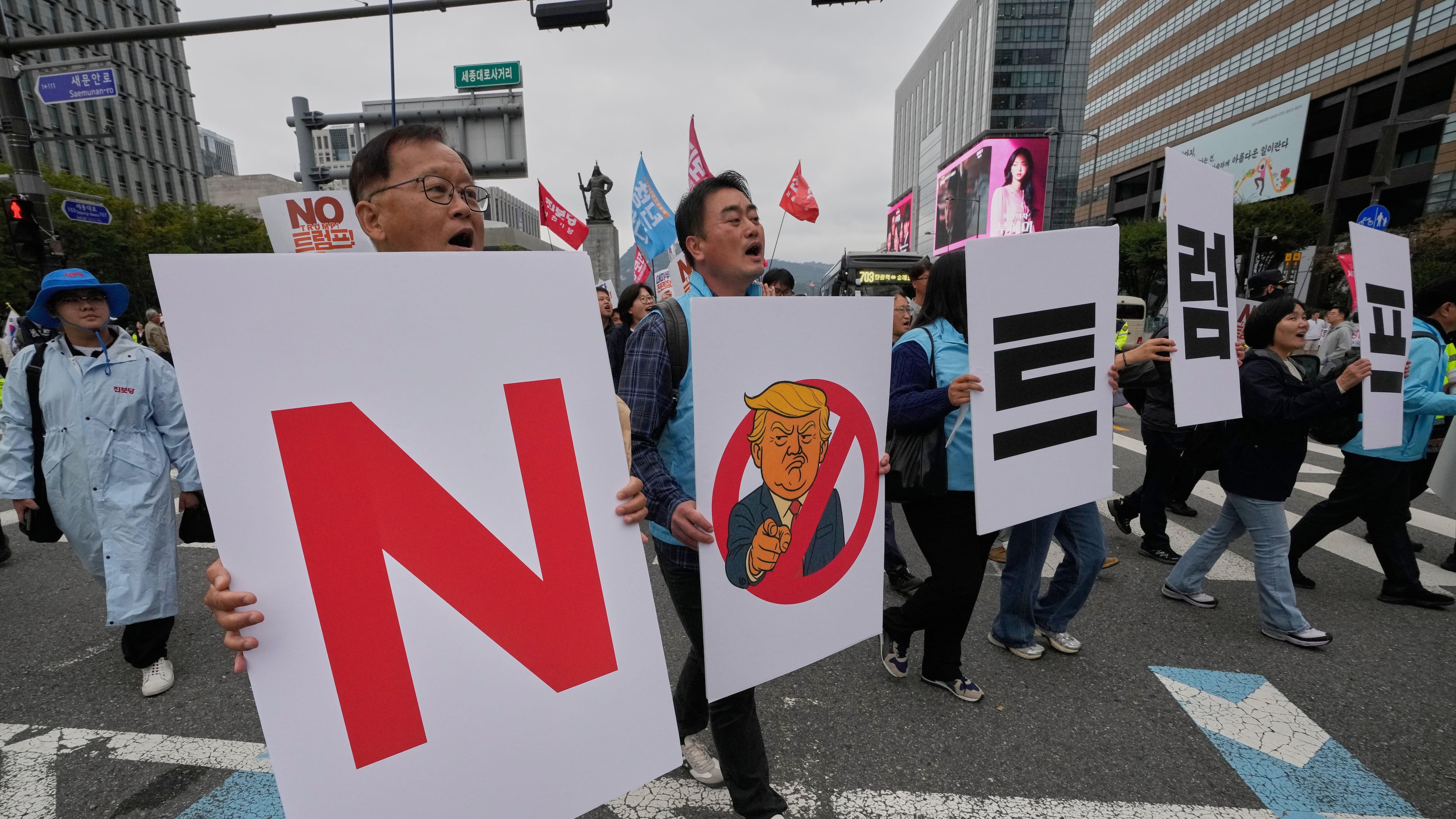 FILE - South Korean protesters march during a rally against U.S. President Donald Trump's tariffs policy on South Korea, in Seoul, South Korea, Oct. 18, 2025. The signs read "No Trump." (AP Photo/Ahn Young-joon, File)