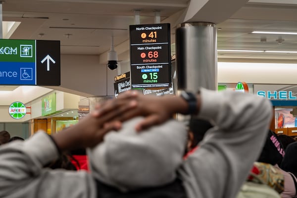 A man reads the wait times for domestic security at Hartsfield-Jackson Atlanta International Airport, Wednesday, March 18, 2026. (Ben Hendren for the AJC)