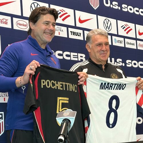 Unites States coach Mauricio Pochettino and Atlanta United coach Tara Martino pose with jerseys during a news conference before the men's national soccer team training, Friday, March 27, 2026, in Marietta, Ga. (AP Photo/Ronald Blum