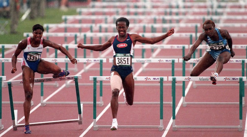 Jackie Joyner-Kersee (#3851) of the U.S. women’s track and field team grimaces in pain after clearing the last hurdle in the Heptathlon 100-meter hurdles at the Olympic Stadium, Saturday, July 27, 1996 during the 1996 Summer Olympic Games in Atlanta. Joyner-Kersee won her heat, but re-injured her right hamstring and had to withdraw from competition. She is flanked by (#3317) Denise Lewis of Great Britain, left, and (#3732) Eunice Barber of Sierra Leone, right. (Cox file photo/E. A. Kennedy, III)