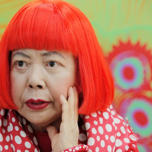 FILE - Japanese avant-garde artist Yayoi Kusama, wearing a bright red wig and a Louis Vuitton polka dot scarf, speaks during an interview at her studio in Tokyo, on Aug. 1, 2012. (AP Photo/Itsuo Inouye, File)