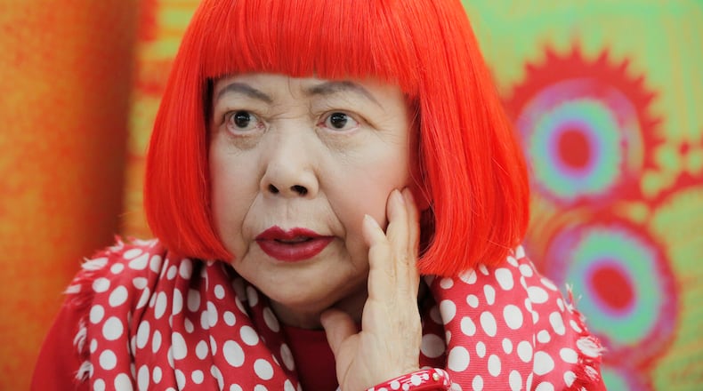 FILE - Japanese avant-garde artist Yayoi Kusama, wearing a bright red wig and a Louis Vuitton polka dot scarf, speaks during an interview at her studio in Tokyo, on Aug. 1, 2012. (AP Photo/Itsuo Inouye, File)