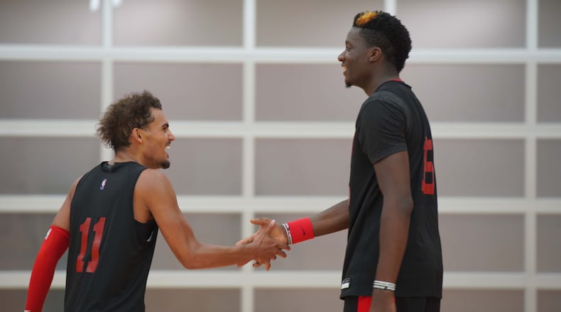 Hawks guard Trae Young celebrates with center Clint Capela during Monday, Sept. 28, 2020, training session at team's practice facility in Atlanta. Capela, who the Hawks acquired at the trade deadline, has not played since Jan. 29 because of a nagging heel injury.