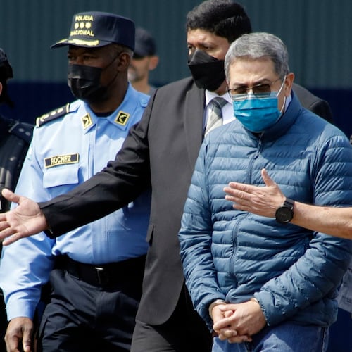 FILE - Former Honduran President Juan Orlando Hernandez, second from right, is taken in handcuffs to a waiting aircraft as he is extradited to the United States, at an Air Force base in Tegucigalpa, Honduras, April 21, 2022. (AP Photo/Elmer Martinez, File)