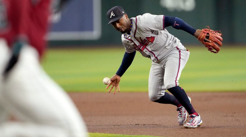 Atlanta Braves' Ozzie Albies bobbles the ball on a base hit by Arizona Diamondbacks' Randal Grichuk during the first inning of a baseball game, Thursday, July 11, 2024, in Phoenix. (AP Photo/Matt York)