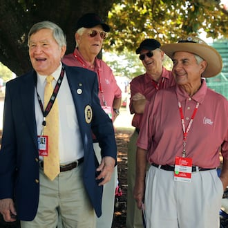 In this file photo, East Lake Foundation founder Tom Cousins, center, jokes with Hole No. 18 volunteers during round two of the 2013 Tour Championship at East Lake Golf Club. (Jason Getz/AJC)