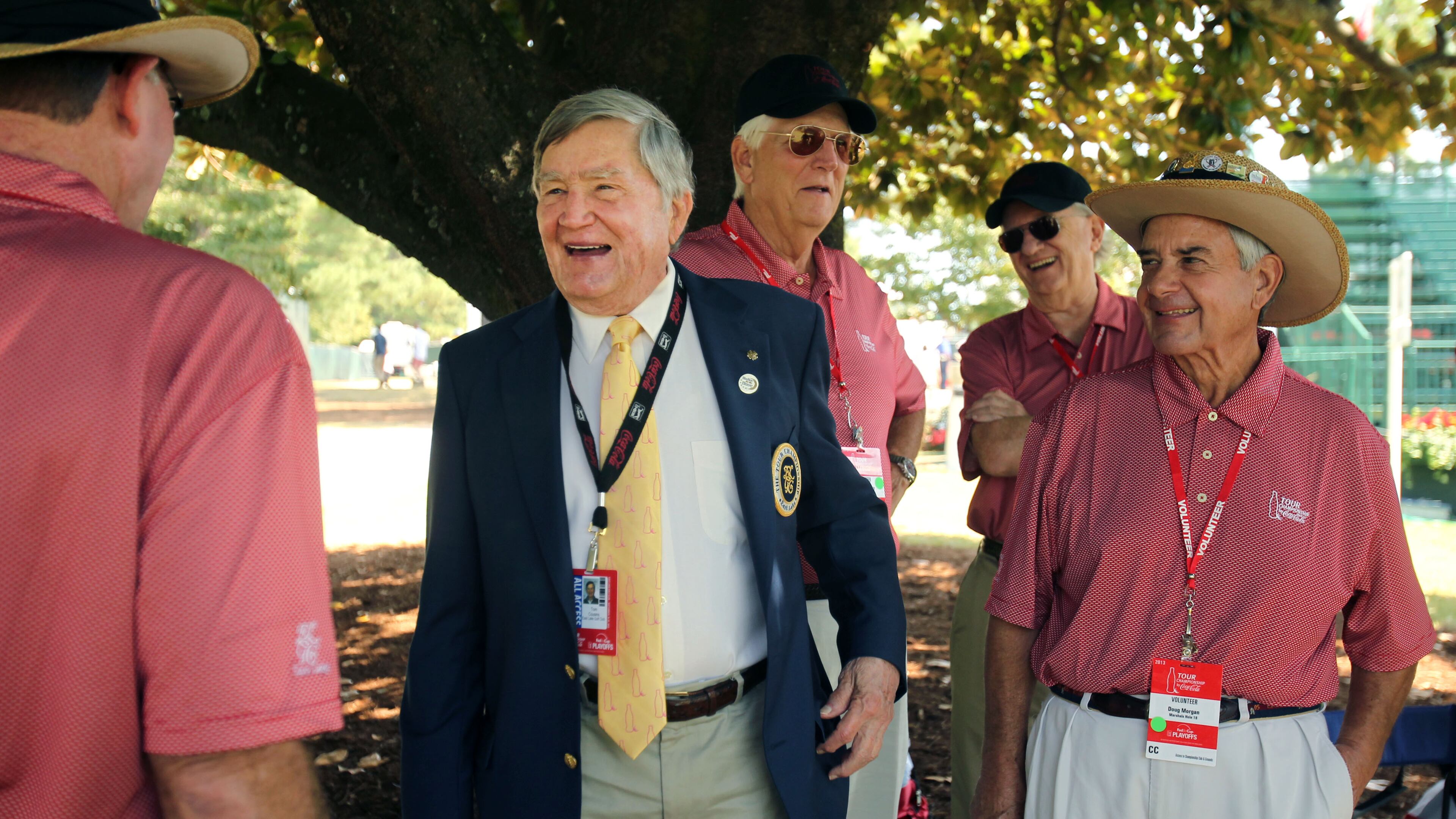East Lake Foundation founder Tom Cousins, center, jokes with Hole No. 18 volunteers during round two of the 2013 Tour Championship at East Lake Golf Club. (Jason Getz / AJC)