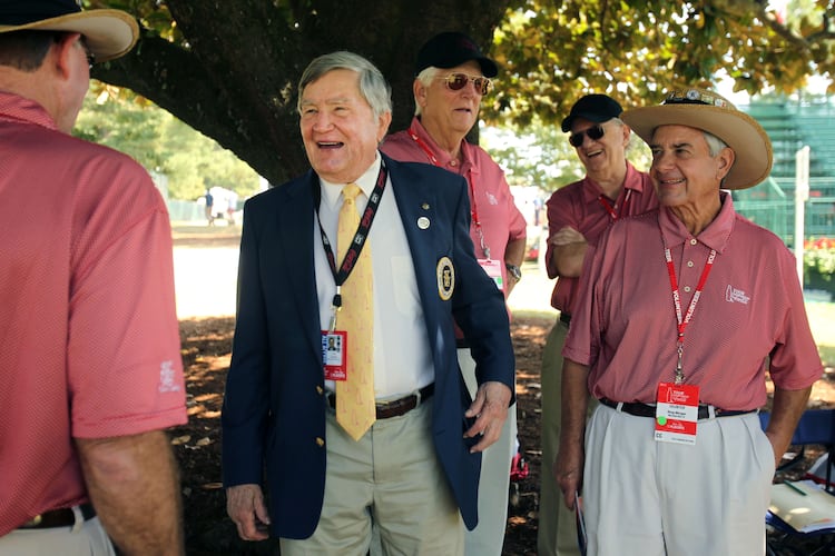 In this file photo, East Lake Foundation founder Tom Cousins, center, jokes with Hole No. 18 volunteers during round two of the 2013 Tour Championship at East Lake Golf Club. (Jason Getz/AJC)