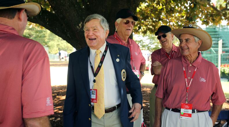 In this file photo, East Lake Foundation founder Tom Cousins, center, jokes with Hole No. 18 volunteers during round two of the 2013 Tour Championship at East Lake Golf Club. (Jason Getz/AJC)