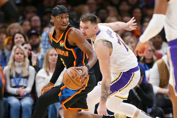 Oklahoma City Thunder guard Shai Gilgeous-Alexander, left, dribbles away from Los Angeles Lakers guard Luka Doncic, right, during the first half of an NBA basketball game Sunday, April 6, 2025, in Oklahoma City. (AP Photo/Nate Billings)