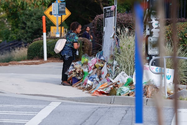 A woman looks at the memorial for DeKalb County police officer David Rose on Monday. (Natrice Miller/ AJC)