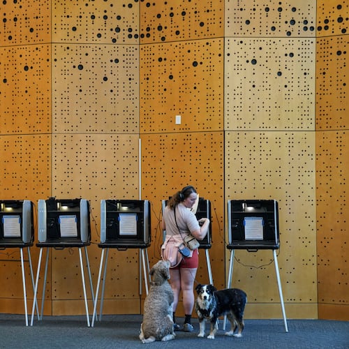 Danielle Grisolano brings her dogs Lincoln and Pepper with her to vote in the Democratic primaries at Denver Public Library, Tuesday, June 30, 2026, in Denver. (AP Photo/Rebecca Slezak)