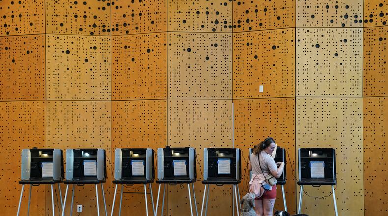 Danielle Grisolano brings her dogs Lincoln and Pepper with her to vote in the Democratic primaries at Denver Public Library, Tuesday, June 30, 2026, in Denver. (AP Photo/Rebecca Slezak)