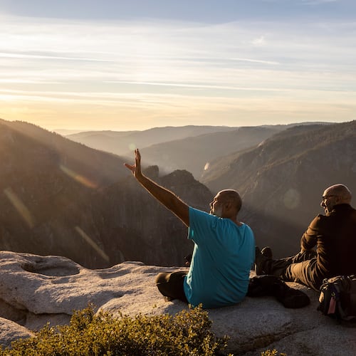 FILE - Visitors watch a sunset on rock ledge near Taft Point in Yosemite National Park, Calif., Oct. 30, 2025. (Stephen Lam/San Francisco Chronicle via AP, File)