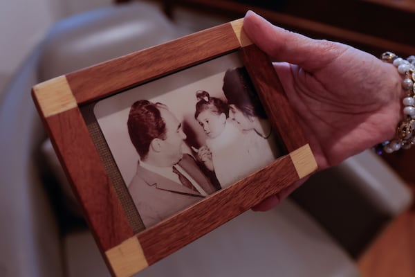 Roya Shahidi holds a baby photo of herself and her parents taken in Iran in 1962 on Wednesday, June 25, 2025. Shahidi lived in Tehran, Iran’s capital city, until she was 16. (Natrice Miller/AJC)