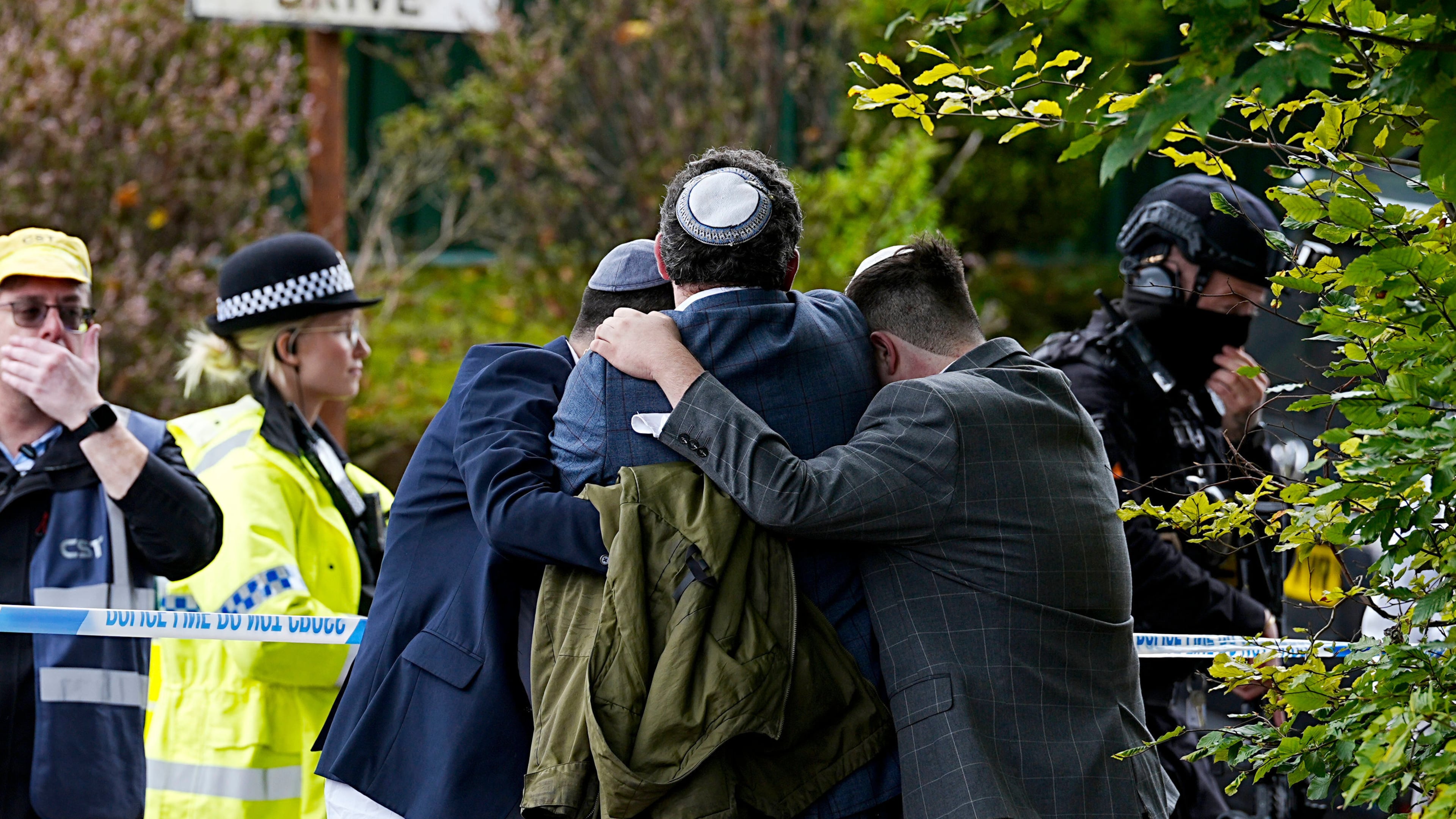 Members of the Jewish community comfort each other near to the Heaton Park Hebrew Congregation synagogue, in Crumpsall, Manchester, England, Thursday, Oct. 2, 2025 after Police reported that two people were killed and three others were seriously injured in a synagogue attack in northern England. (Peter Byrne/PA via AP)