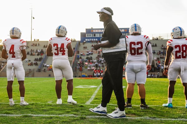 Heritage High coach Quincy Carter walks by his captains before their first game of the season against Cedar Shoals on Friday, Aug. 21, 2026, in Athens. Carter was named Heritage’s coach in December. (Abbey Cutrer/AJC)
