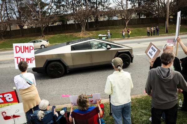 Protestors gather in front of a Tesla dealership in Owings Mills, Md., on Saturday, March 29, 2025. (Wesley Lapointe/The Baltimore Banner via AP)