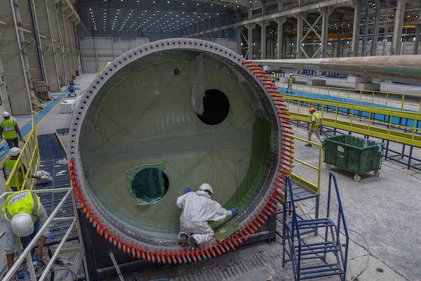 FILE - Employees work on a wind turbine blade at the Adani New Industries Limited in the port town of Mundra in Western India's Gujarat state, India, Sept. 20, 2023. (AP Photo/Rafiq Maqbool, File)