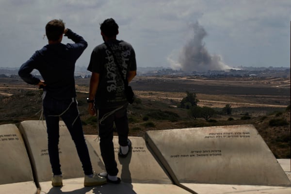 People watch smoke rising to the sky after an explosion in the Gaza Strip as they visit a sightseeing area in Sderot, southern Israel, Thursday, May 22, 2025. (AP Photo/Leo Correa)