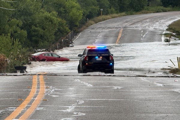 A police vehicle blocks a flooded roadway in San Antonio, Tx., where a vehicle was stranded after heavy rains in the city on Thursday, June 12, 2025. (AP Photo/Lekan Oyekanmi)