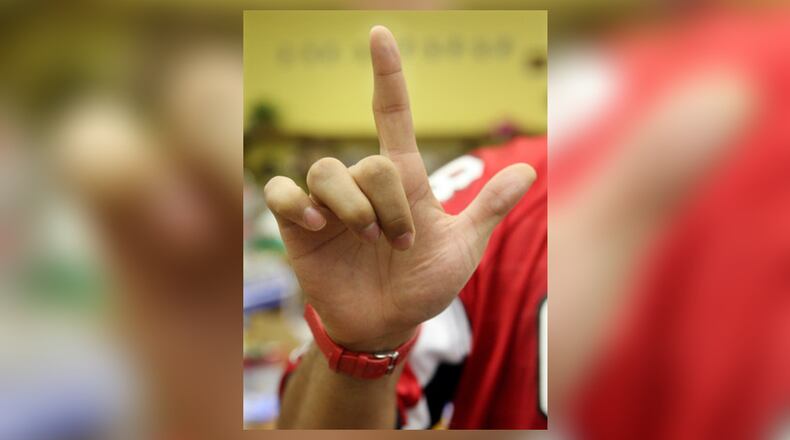 Falcons defensive end Jamaal Anderson signs the letter L as he spells his name while visiting the Atlanta Area School for the Deaf in this AJC file photo. Students and former employees are unhappy with the school's new superintendent hired by the state.