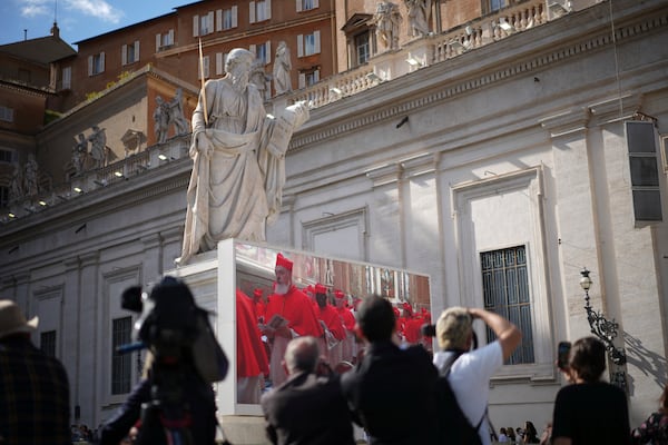 Photographers take pictures of a giant screen showing images of cardinals entering the conclave, in St. Peter's Square at the Vatican, Wednesday, May 7, 2025. (AP Photo/Andrew Medichini)