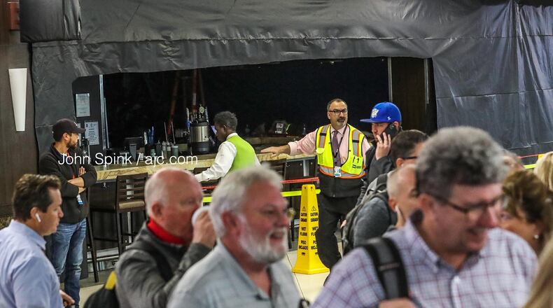 Cat Cora's Kitchen was covered in black plastic after part of the restaurant's ceiling collapsed on diners Thursday morning. Two people were injured, according to Hartsfield-Jackson International Airport officials.