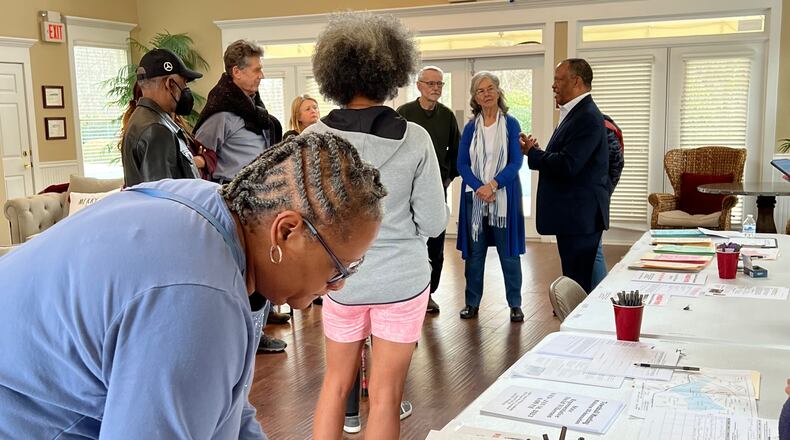 Resident Stacey Walker signs a petition to de-annex from the city of Mableton at a signing event January 7, 2023, in Mableton while other residents talk with state Rep. David Wilkerson. Photo provided