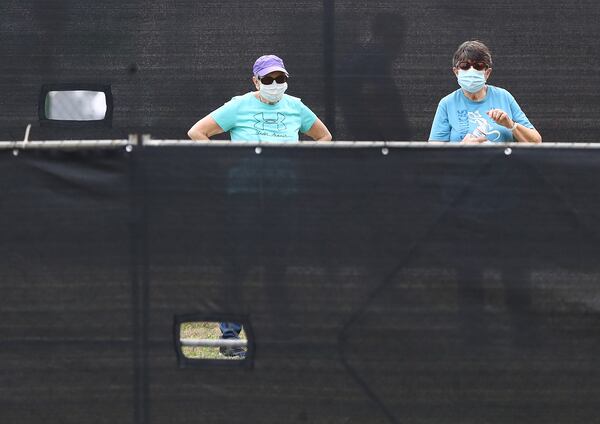 March 12, 2020 Marietta: A pair of women wearing masks are seen behind a blackened fence where quarantined Grand Princess cruise ship passengers are isolated in a housing area at Dobbins Air Reserve Base on Thursday, March 12, 2020, in Marietta. âPrior to arriving here, the passengers were medically screened by the U.S. Department of Health and Human Services and Centers for Disease Control and Prevention,â said Col. Craig McPike, Dobbins installation commander. âThe passengers who were asymptomatic were transferred here and other federal military installations for COVID-19 testing and quarantine.â Should any individuals be identified as ill during their quarantine period, the Department of Health & Human Services, the lead federal agency, has procedures in place to transport them to a local civilian hospital. âCDC is fully responsible for all aspects of the quarantine operation, and Dobbins personnel will have no contact with these passengers. By providing this support, Dobbins ARB is helping to protect the health of Americans by preventing the spread of the virus.â    Curtis Compton ccompton@ajc.com