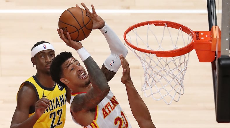 Hawks forward John Collins grabs the offensive rebound and goes to the board against the Indiana Pacers Sunday, April 18, 2021, at State Farm Arena in Atlanta. (Curtis Compton / Curtis.Compton@ajc.com)