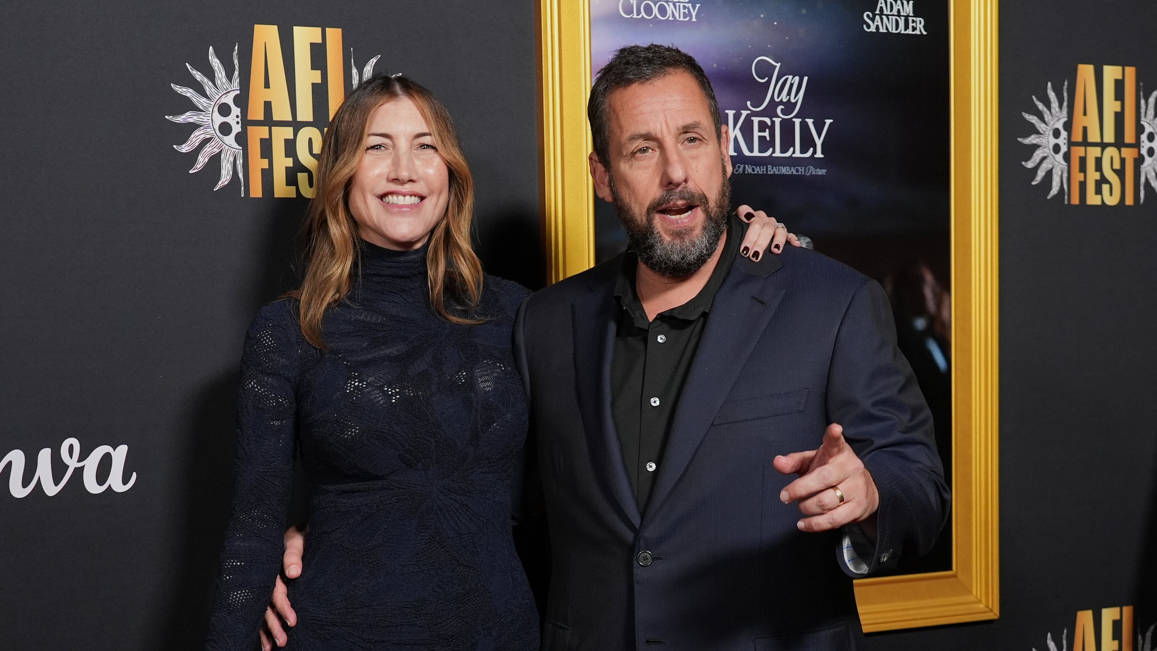Adam Sandler, right, a cast member in "Jay Kelly," arrives with his wife Jackie Sandler at the AFI Fest premiere of the film on Thursday, Oct. 23, 2025, at TCL Chinese Theatre in Los Angeles. (AP Photo/Chris Pizzello)