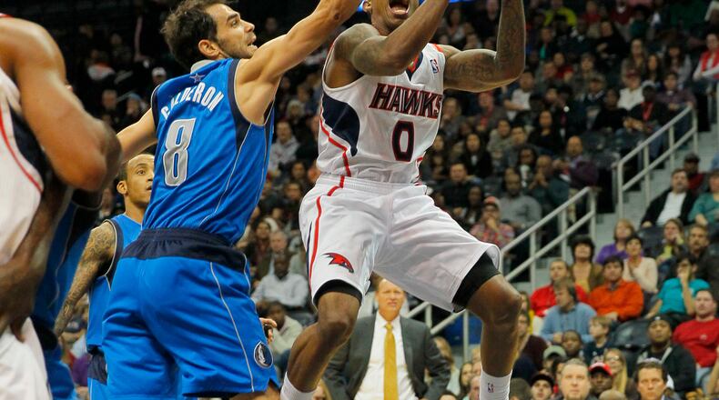 Atlanta Hawks point guard Jeff Teague (0) shoots over Dallas Mavericks point guard Jose Calderon (8) in the second period of an NBA basketball game in Atlanta, Friday, Nov. 29, 2013. (AP Photo/Todd Kirkland)