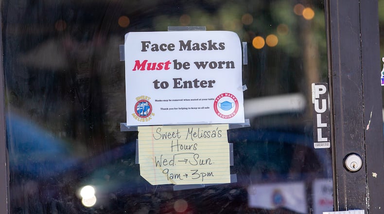 A sign requiring masks is taped to the door to the door of Sweet Melissa's in Decatur Monday, February 28, 2022.  STEVE SCHAEFER FOR THE ATLANTA JOURNAL-CONSTITUTION
