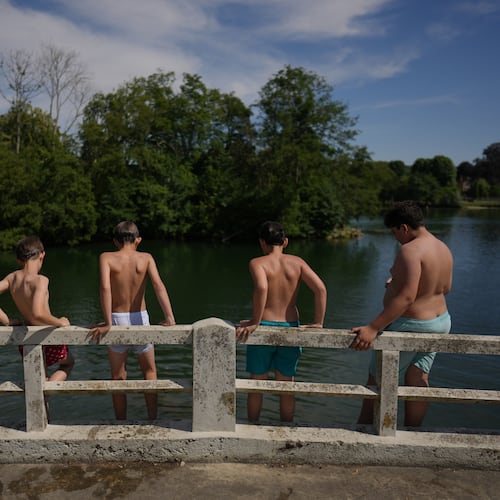 Young boys prepare to dive in the Seine river, in Samois-sur-Seine, south of Paris, Friday, June 19, 2026. (AP Photo/Thibault Camus)