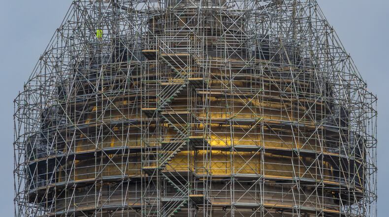 Workers are replacing the iconic gold leaf atop the dome of the Georgia Capitol as part of $392 million worth of renovations that include a new legislative office building, parking deck, meeting rooms, offices and air conditioning system. A series of budget surpluses have left Georgia flush with cash to pay for such projects. (John Spink/AJC 2024)
