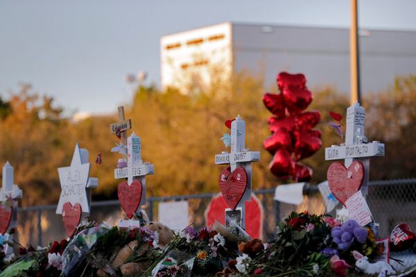 FILE - A memorial is stands outside the Marjory Stoneman Douglas High School where 17 students and faculty were killed in a mass shooting in Parkland, Fla, Feb. 19, 2018. (AP Photo/Gerald Herbert, File)
