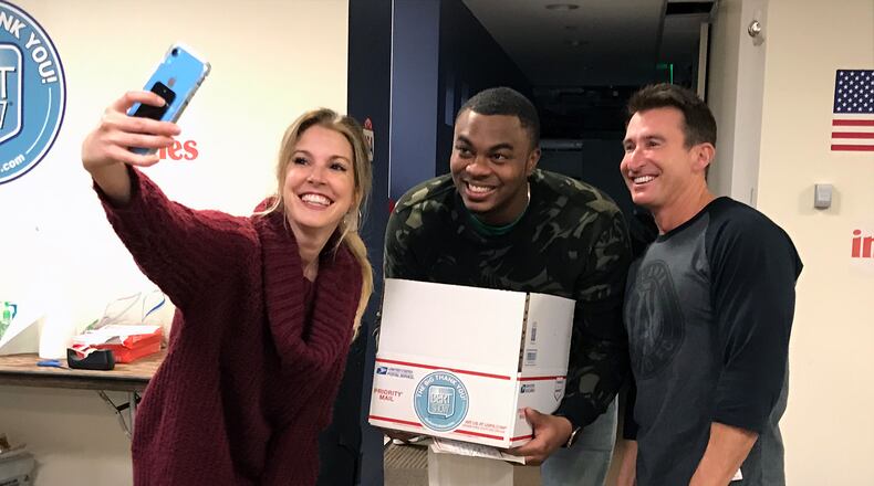 Radio hosts Kristin Klingshirn (left), Moe Mitchell (center) and Bert Weiss in November 2019 during a charity event where the "Bert Show" collected letters for American military overseas during Thanksgiving. (Rodney Ho/AJC 2019)